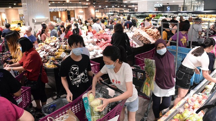 Potret Warga Malaysia Serbu Pusat Perbelanjaan Shoppers looking at empty shelves at a supermarket in Kuala Lumpur, Malaysia, Tuesday, March 17, 2020. Malaysia has the highest number of cases in Southeast Asia and the fourth highest in Asia following a spike in recorded coronavirus cases after China, South Korea and Japan. For most people, the new coronavirus causes only mild or moderate symptoms. For some it can cause more severe illness. (AP Photo)