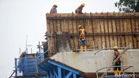Pekerja membangun tiang flyover.