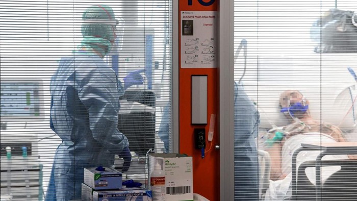 Medical workers wearing a face make and protection gear teand to a patient inside the new coronavirus intensive care unit of the Brescia Poliambulanza hospital, Lombardy, on March 17, 2020. (Photo by Piero CRUCIATTI / AFP)