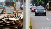 Kendaraan melintas di samping proyek pembangunan flyover Lenteng Agung, Rabu (18/3).