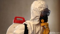 Petugas tampak mengenakan pakaian khusus, masker, dan kacamata saat melakukan penyemprotan disinfektan di kawasan Masjid Al-Ukhuwwah.