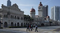 Independence Square di Kuala Lumpur terlihat lengang. Beberapa orang berjalan kaki terlihat memakai masker wajah (AP/Vincent Thian)