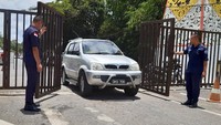 Dua petugas keamanan membuka pintu untuk mobil warga Malaysia yang hendak pulang ke negara asalnya melalui Pos Lintas Batas Negara (PLBN) Entikong di Kabupaten Sanggau, Kalimantan Barat.