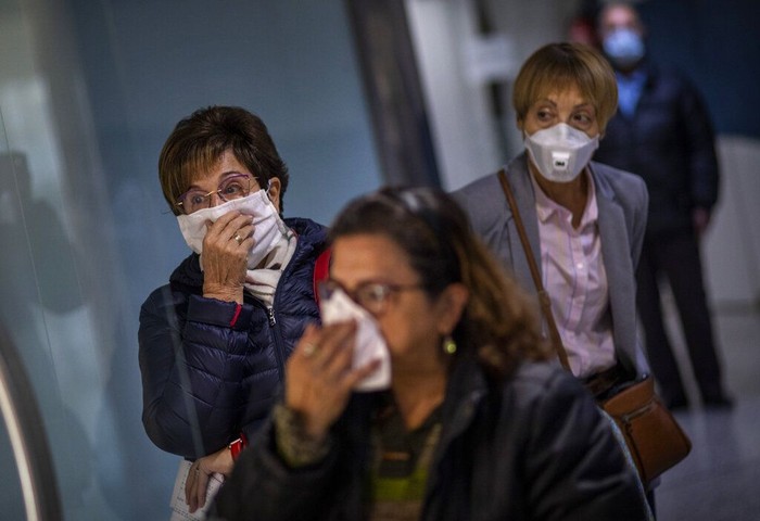 Wabah Virus Corona di Spanyol A man wearing a face mask walks in downtown Madrid, in Spain, Wednesday, March 18, 2020. Spain will mobilize 200 billion euros or the equivalent to one fifth of the countrys annual output in loans, credit guarantees and subsidies for workers and vulnerable citizens, Prime Minister Pedro Sánchez announced Tuesday. For most people, the new coronavirus causes only mild or moderate symptoms. For some, it can cause more severe illness, especially in older adults and people with existing health problems. (AP Photo/Manu Fernandez)