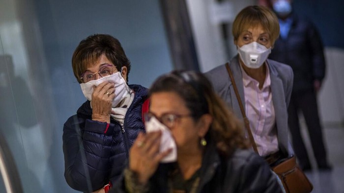 A man wearing a face mask walks in downtown Madrid, in Spain, Wednesday, March 18, 2020. Spain will mobilize 200 billion euros or the equivalent to one fifth of the countrys annual output in loans, credit guarantees and subsidies for workers and vulnerable citizens, Prime Minister Pedro Sánchez announced Tuesday. For most people, the new coronavirus causes only mild or moderate symptoms. For some, it can cause more severe illness, especially in older adults and people with existing health problems. (AP Photo/Manu Fernandez)