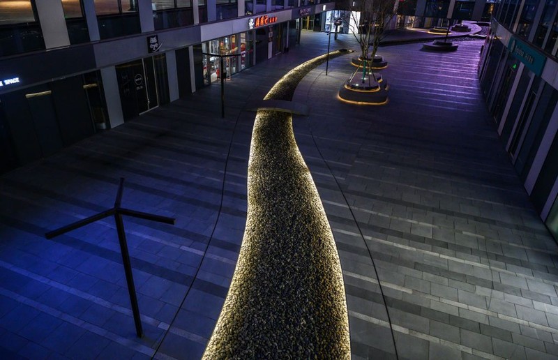 BEIJING, CHINA - MARCH 10: The empty courtyard of a usually busy shopping mall is seen on March10, 2020 in Beijing, China.  In Beijing, the normally bustling capital has fallen into a rhythm of social distancing that is widely accepted as the new norm after two months of restrictions to stop the disease from spreading. Millions of people are still working from home, schools and entertainment venues remain closed, and even commutes on some public transit need to be pre-booked to control crowds.  At the same time, China has been grappling with how to restart and revive the world's second largest economy without triggering another wave of infections, especially in the home of the country's political leadership.  So, while the cautious return of economic activity in Beijing has meant more road traffic and street life during the day, evening brings a return to the familiar quiet anxiety that has defined China's efforts to contain the virus.  After sunset, a majority of people avoid mingling or limit their interactions, and largely retreat to home. Retail stores follow reduced hours of operation, restaurants limit the number of people who can dine, and large gatherings are still banned. Residential areas have controls in place to restrict entry, and tighter quarantine rules require people returning to Beijing from other cities or countries to abide by a 14-day isolation period that is monitored and enforced.  Authorities are sensitive to so-called imported cases of the coronavirus with nearly 81,000 cases of COVID-19 in China and more than 3200 deaths, mostly in and around the city of Wuhan, in central Hubei province, where the outbreak first started. (Photo by Kevin Frayer/Getty Images)