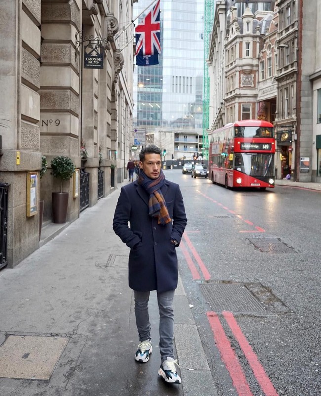 Liburan di London, Inggris, pria keturunan Belanda-Minang ini jalan-jalan pakai coat navy berikut scarf motif. Jeans abu-abu dan sneakers jadi pilihan untuk bawahan. (Foto: Instagram/@raphaelmaitimo)