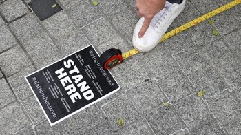 Seorang pekerja mengukur jarak antrian di restoran Chef Jose Andres dalam respon pencegahan penularan COVId-19. Foto: Getty Images