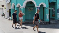 Beberapa turis asing yangv terjebak di Malaysia terlihat maih berada di beberapa titik. Namun toko-toko nyaris semuanya tutup (AFP/GOH CHAI HIN)