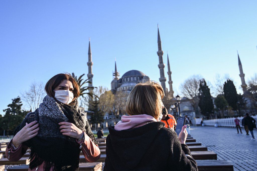 Women wear protective face masks near Sultanahmet Mosque also known as the Blue Mosque as the nation tries to contain the novel coronavirus, COVID-19, in Istanbul on March 17,2020. - Turkey on Monday suspended collective mosque prayers until further notice to limit the spread of the new coronavirus, while ordering the closure of public spaces including cinemas. The interior ministry later Monday said theatres, cinemas, concert halls, restaurants where there is live music, shisha cafes and places serving tea and coffee,night clubs,bars would be closed 
