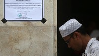 Pengumuman peniadaan salat Jumat ditempel di dinding masjid.