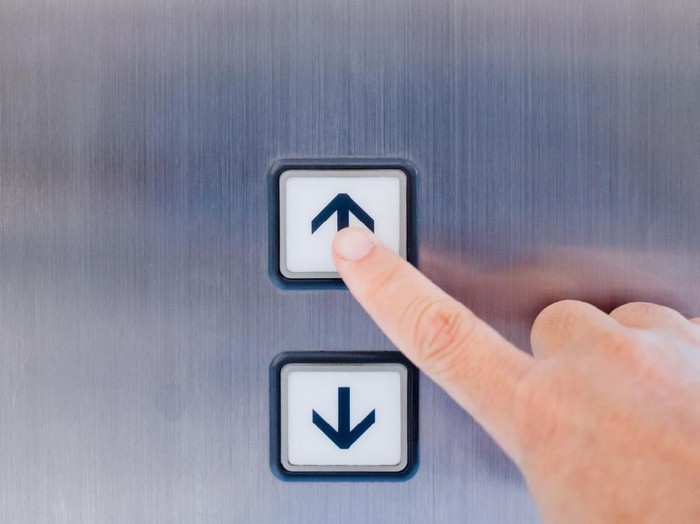 Tempat Penuh Kuman Hand pressing the button in the elevator in front view