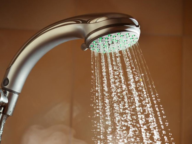 Shower woman showering relaxing under water massaging neck in hot shower. Asian female adult face enjoying spa relaxation time relaxing meditating in warm bath cleaning face and body at home.