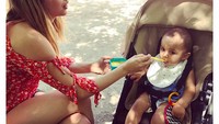 Di Madrid, Ana sedang jadi babysitter nih. Ia telaten menyuapi bubur ke bayi laki-laki yang menggemaskan. Foto: Instagram ana_d_armas