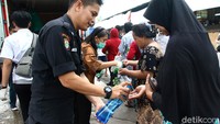 Para pembeli mencuci tangan sebelum membeli bahan pokok yang dijual dalam operasi pasar. Mereka mencuci tangan untuk mengantisipasi penyebaran virus corona.