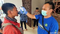 Beberapa petugas kesehatan dan petugas Dokpol Polres Sukabumi Kota satu persatu mereka memeriksaa jamaah yang datang dengan menembakan alat thermo gun.