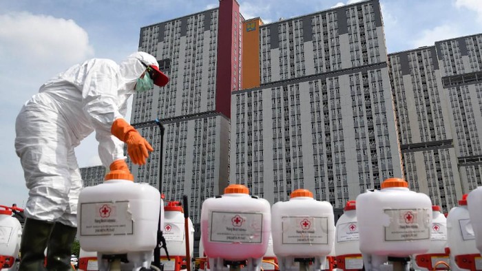 Petugas Palang Merah Indonesia (PMI) memakai kacamata pelindung untuk melakukan penyemprotan cairan disinfektan pada Wisma Atlet di Kemayoran, Jakarta, Sabtu (21/3/2020). Pemerintah menyiapkan Wisma Atlet Kemayoran sebagai rumah sakit darurat penanganan virus COVID-19 serta akan menjadi rumah isolasi bagi pasien yang rencannya akan digunakan pada hari ini, Sabtu (21/3/2020). ANTARA FOTO/M Risyal Hidayat/hp.