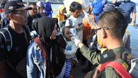 Petugas kesehatan memeriksa suhu tubuh penumpang KMP Dharma Kartika di Pelabuhan Jangkar, Situbondo, Jawa Timur, Sabtu (21/3/2020).