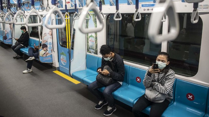 Penumpang duduk di bangku yang telah diberi stiker panduan jarak antarpenumpang di rangkaian gerbong kereta MRT, Jakarta, Jumat (20/3/2020). Sebagai tindakan pencegahan penyebaran virus Corona atau COVID-19, pemerintah telah memberikan arahan kepada seluruh masyarakat untuk mulai menerapkan praktik 