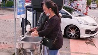Tampak masyarakat sedang menggunakan fasiltas cuci tangan yang disediakan di Kantor Cabang Bank BRI Blitar, Sabtu (21/3). Foto: dok. BUMN