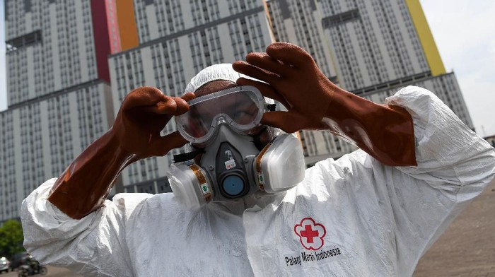 Petugas Palang Merah Indonesia (PMI) memakai kacamata pelindung untuk melakukan penyemprotan cairan disinfektan pada Wisma Atlet di Kemayoran, Jakarta, Sabtu (21/3/2020). Pemerintah menyiapkan Wisma Atlet Kemayoran sebagai rumah sakit darurat penanganan virus COVID-19 serta akan menjadi rumah isolasi bagi pasien yang rencannya akan digunakan pada hari ini, Sabtu (21/3/2020). ANTARA FOTO/M Risyal Hidayat/hp.