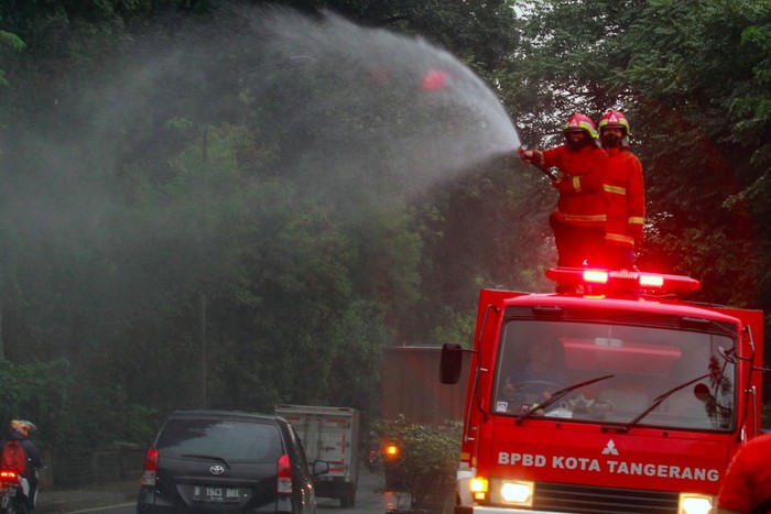 PENYEMPROTAN DISINFEKTAN JALAN RAYA DAAN MOGOT Petugas dari Dinas Pemadam Kebakaran dan BPBD Kota Tangerang dengan mobil pemadam melakukan penyemprotan cairan disinfektan terhadap ruang udara dan rambu lalulintas di Jalan Raya Daan Mogot, Tangerang, Banten, Jumat (20/3/2020). Penyemprotan dilakukan untuk meminimalisir penyebaran COVID-19 di ruang udara dan ruas jalan yang menghubungan dua provinsi yakni Jakarta dengan Banten. ANTARA FOTO/Muhammad Iqbal/foc.