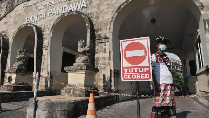 Petugas berjaga di kawasan wisata Pantai Pandawa yang ditutup sementara di Badung, Bali, Sabtu (21/3/2020). Pengelola sejumlah destinasi pariwisata di wilayah Kabupaten Badung seperti Pantai Pandawa, kawasan Garuda Wisnu Kencana, Hutan Kera Sangeh serta Taman Ayun mulai menghentikan operasionalnya sementara sebagai salah satu upaya pencegahan penyebaran COVID-19 atau Virus Corona. ANTARA FOTO/Fikri Yusuf/aww.