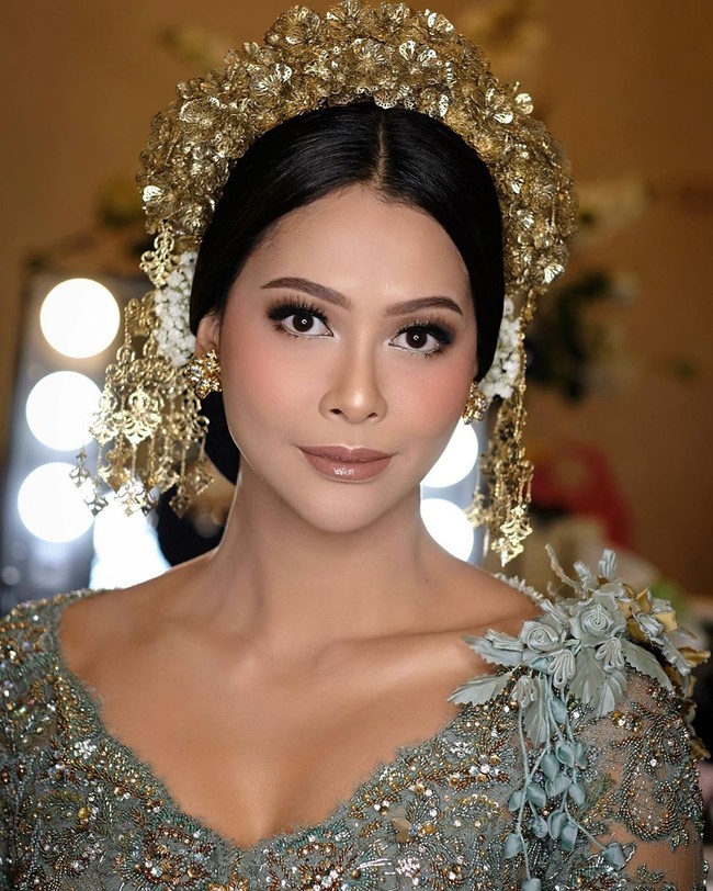 Dekorasi pernikahan didominasi nuansa emas dengan rangkaian bunga mawar warna beige dan oranye, kreasi Rumah Kampung Decor. Foto: Instagram/@hepidavid, @aldiphoto, @mozawahyu