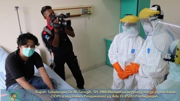 Sebuah foto yang menunjukkan ada kamerawan tanpa alat pelindung diri (APD) mengikuti Bupati Simalungun JR Saragih mengecek orang dalam pemantauan (ODP) virus corona atau COVID-19 viral.