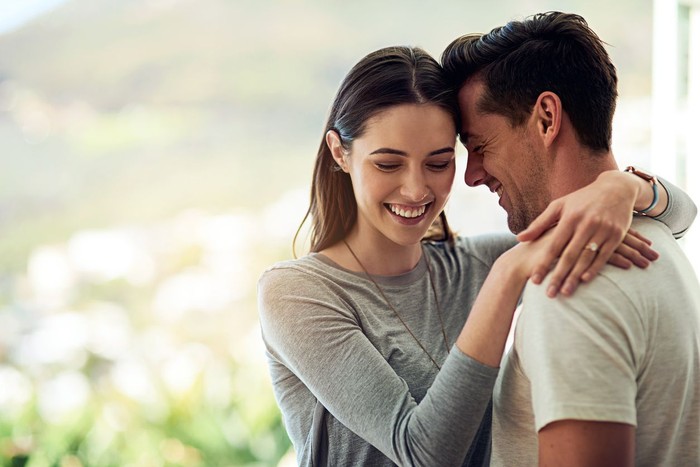 638526574 Shot of a happy young couple in a loving embrace