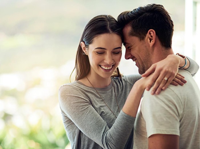 638526574 Shot of a happy young couple in a loving embrace