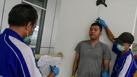Petugas mengukur tinggi badan calon relawan saat tes kesehatan di kompleks Wisma Atlet di Kemayoran, Jakarta, Minggu (22/3/2020).