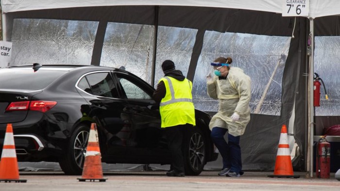 Health professionals conduct coronavirus tests at a drive through testing site at the University of Dayton in Dayton, Ohio on March 17, 2020. - The coronavirus outbreak has transformed the US virtually overnight from a place of boundless consumerism to one suddenly constrained by nesting and social distancing. (Photo by Megan JELINGER / AFP)