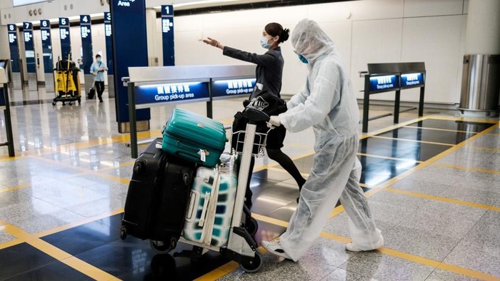 A passenger wears protective gear, as a precautionary measure against the COVID-19 coronavirus, after arriving at Hong Kongs international airport on March 19, 2020. (Photo by ANTHONY WALLACE / AFP)