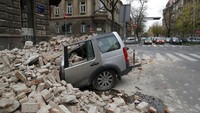 Sebuah mobil tampak rusak tertimpa puing-puing bangunan usai wilayah Kroasia diguncang gempa 5,3 M. AP Photo/Darko Bandic.