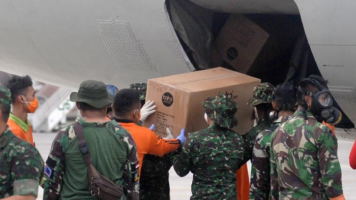 Petugas memindahkan Alat Pelindung Diri (APD) dari pesawat B737-400 milik TNI AU di Bandara I Gusti Ngurah Rai, Bali, Senin (23/3/2020). Ribuan APD dengan berat total 1,6 ton yang dikirim dari Lanud Halim Perdanakusuma tersebut selanjutnya akan didistribusikan ke beberapa rumah sakit di wilayah Bali, NTB dan NTT untuk penanganan COVID-19 atau virus Corona. ANTARA FOTO/Fikri Yusuf/foc.