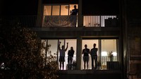 Sejumlah orang di Spanyol juga tampak berbincang dengan tetangga sebelah tempat tinggalnya di balkon rumah untuk mengusir kejenuhan selama melakukan isolasi diri guna memutus rantai penyebaran virus Corona di kawasan Barcelona, Spanyol. AP Photo/Emilio Morenatti.