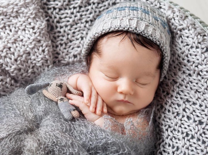 1177345597 Newborn baby boy sleeping and dreaming with arms behind his head
