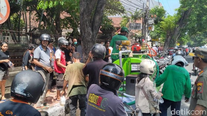 Satpo PP Denpasar membubarkan kerumunan massa yang antre disinfektan gratis.