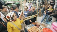 Saat meninjau kawasan PKL Cicadas,  Bandung, ia juga menyempatkan untuk berinteraksi dengan para pedagang. Salah satunya pada penjual makanan dan kolak kaki lima. Dengan senyum lebarnya, ia berpose dengan beberapa gelas kecil kolak. Foto: Instagram @kangyanamulyana