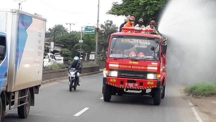 Petugas Damkar menyemprotkan disinfektan di jalur Pantura