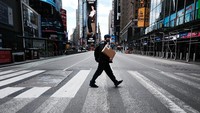 Seorang pria menyeberang jalan di Times Square yang terlihat lengang. Padahal lokasi ini sebelumnya selalu menjadi pusat keramaian kota New York (Getty Images/Spencer Platt)