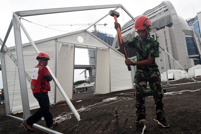 PMI BANGUN GUDANG LOGISTIK PENANGANAN COVID-19 Petugas PMI membangun tenda untuk gudang logistik tambahan penanganan COVID-19 di kawasan Jalan Gatot Subroto, Jakarta, Senin (23/3/2020). Gudang logistik tersebut nantinya akan digunakan untuk menyimpan peralatan semprot, cairan disinfektan, sarung tangan, sepatu bot, kacamata google serta masker dan baju steril. ANTARA FOTO/Indrianto Eko Suwarso/ama.