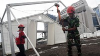 Petugas membangun tenda yang akan digunakan sebagai gudang logistik penanganan virus corona (covid-19)di kawasan Jalan Gatot Subroto, Jakarta, Selasa (24/03/2020) . Gudang itu untuk menyimpang peralatan semprot, cairan disinfektan hingga baju steril. Antara/Indrianto Eko Suwarso