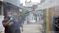 Warga bergotong royong menyemprotkan desinfektan.