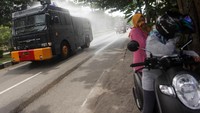 Petugas Polda Kalteng menyemprotkan cairan disinfektan menggunakan mobil water canon di kawasan kota Palangkaraya, Kalimantan Tengah, Selasa (24/3/2020). Penyemprotan disinfektan serentak di 12 titik kota Palangkaraya tersebut sebagai upaya pemerintah setempat guna mencegah penyebaran virus corona.
