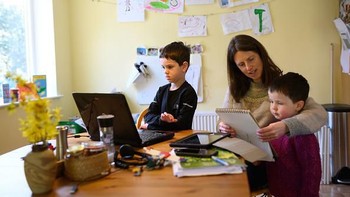 Leo (6) dan Espen (3) ditemani ibunya Moira belajar di rumah (homeschool), di Huddersfield, Inggris, (Senin (23/3/2020). Senin kemarin merupakan hari pertama belajar di rumah sejak kota tersebut ditutup untuk segala aktifitas luar rumah. Kebijakan tersebut untuk meminimalisir penyebaran virus COVID-19.  (Photo by OLI SCARFF/AFP via Getty Images)