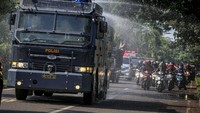 Petugas kepolisian Polresta Tangerang menyemprotkan cairan disinfektan menggunakan mobil Water Canon di Tigaraksa, Kabupaten Tangerang, Banten, Selasa (24/3/2020).