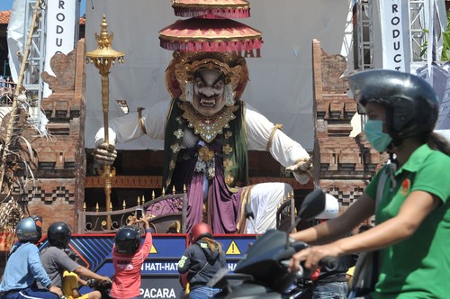 Warga mengamati Ogoh-ogoh yang dibuat menjelang Hari Raya Nyepi Tahun Saka 1942 di Denpasar, Bali, Minggu (22/3/2020). Gubernur Bali Wayan Koster menginstruksikan larangan pelaksanaan pengarakan Ogoh-ogoh dalam bentuk apapun yang berpotensi menimbulkan keramaian dan kerumuman orang di seluruh wilayah Bali sebagai upaya pencegahan penyebaran COVID-19. ANTARA FOTO/Fikri Yusuf/foc.