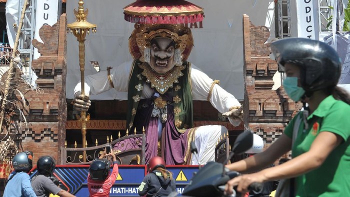 Warga mengamati Ogoh-ogoh yang dibuat menjelang Hari Raya Nyepi Tahun Saka 1942 di Denpasar, Bali, Minggu (22/3/2020). Gubernur Bali Wayan Koster menginstruksikan larangan pelaksanaan pengarakan Ogoh-ogoh dalam bentuk apapun yang berpotensi menimbulkan keramaian dan kerumuman orang di seluruh wilayah Bali sebagai upaya pencegahan penyebaran COVID-19. ANTARA FOTO/Fikri Yusuf/foc.